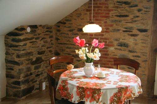 une table avec un vase de fleurs sur elle dans l'établissement Gite Fleurs d'Esse, à Saint-Paul-la-Roche