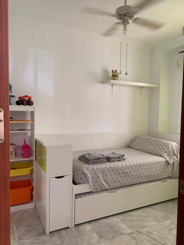 a small bedroom with a bed and a shelf at CASA ALICIA in Torre del Mar