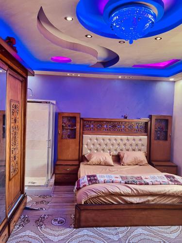 a bedroom with a large bed with a blue ceiling at Wadi rum village bed and breakfast in Wadi Rum