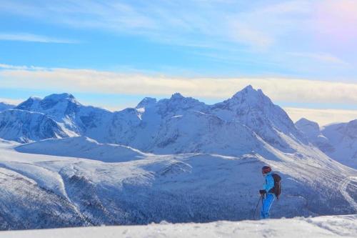 a person standing on top of a snow covered mountain at Kavliskogen panorama in Isfjorden