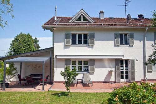 a white house with a patio and a table at Ferienwohnung Deubzer in Palling in Palling