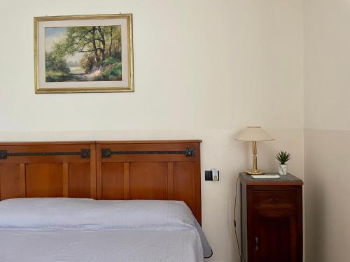 a bedroom with a bed and a picture on the wall at A Paranza in Curtatone