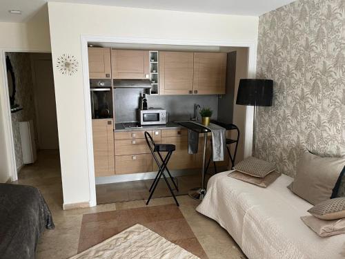 Habitación con cocina con cama y microondas. en Cosy résidence du port, en Cannes
