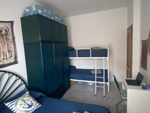 a small room with bunk beds and a blue couch at Casa Bouganville, vista mare! in Lipari