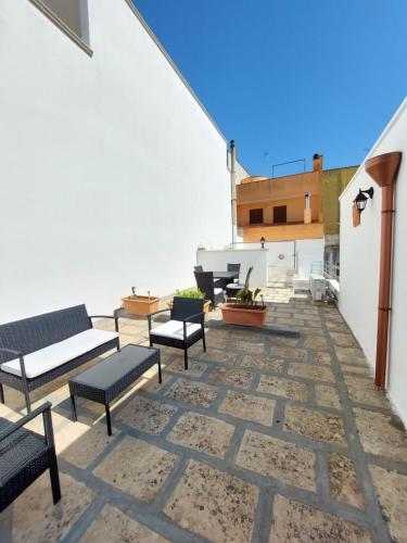 un patio avec des bancs et des tables dans un bâtiment dans l'établissement Salento Gallipoli Dream Life, à Parabita