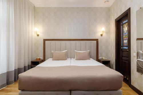a bedroom with a large bed with two pillows at Feder Boutique Hotel in Lviv