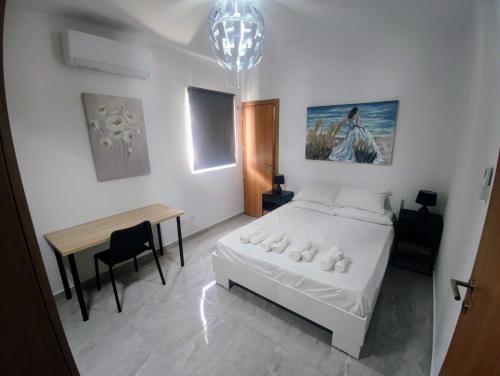 Un dormitorio con una cama, una mesa y un escritorio. en Deggies Apartments - spacious, modern apartment!, en Naxxar