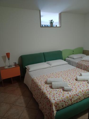 een slaapkamer met 2 bedden en handdoeken bij CASA ORCHIDEA in Carlentini