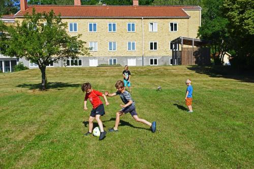 a group of children playing with a soccer ball in a field at Sankt Anna Resort in Sankt Anna
