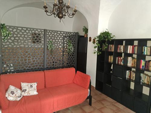 a living room with a red couch and book shelves at Juventus Stadium - comfort e relax in Turin