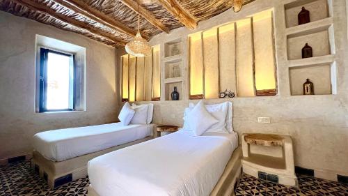 a bedroom with two beds and a window at Dar Salam Souss in Taroudant