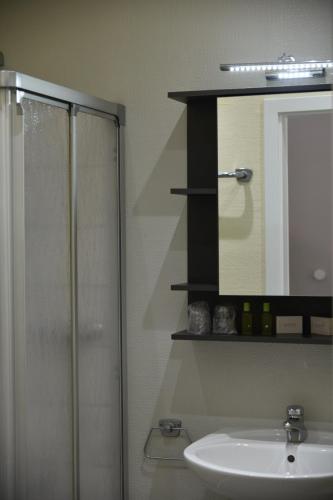 a bathroom with a shower and a sink and a mirror at Gästehaus Lietzow & Störtebeker Camp in Lietzow