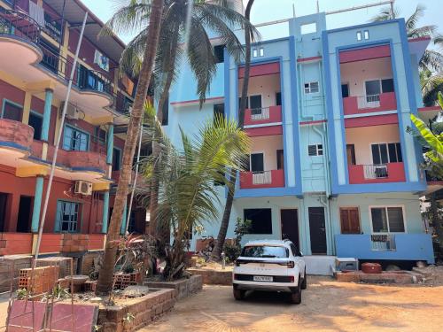 a white truck parked in front of a building at Nimmu Guest House & Restaurant Gokarna in Gokarna