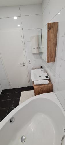een badkamer met een wit bad en een wastafel bij Adler-Haus in Paderborn