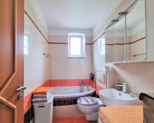 a bathroom with a tub and a toilet and a sink at Apartment Bayreuth, Große Ferienwohnung im Haus mit Kunst, 3 Schlafzimmer, Küche, Parkplatz in Bayreuth
