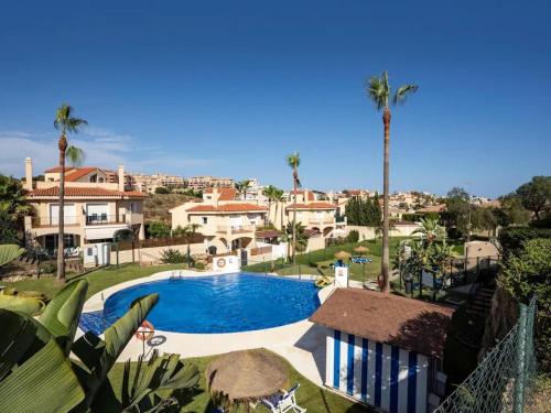a view of a swimming pool with palm trees and houses at Holidays2Riviera, Villa 4 bedrooms & 3 bathrooms & Terraces & Jacuzzi & Pool in Mijas