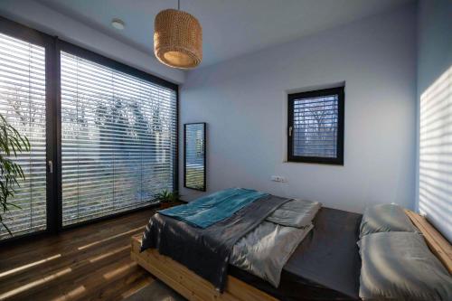 una camera con un letto in una stanza con ampie finestre di Privatzimmer nahe Legoland a Niederstotzingen