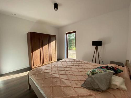 a bedroom with a large bed and a window at Mazurskie Energie dom ekologiczny całoroczny in Stare Juchy
