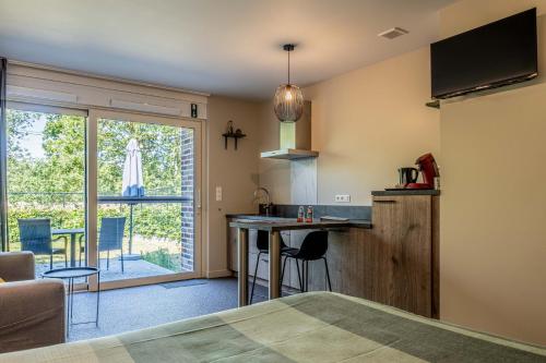 een kamer met een keuken en een tafel met stoelen bij Bleekhoeve in Olen