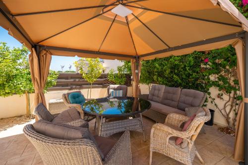 a patio with a table and chairs under an umbrella at Anna-Maria 3 bedroom villa in Paralimni