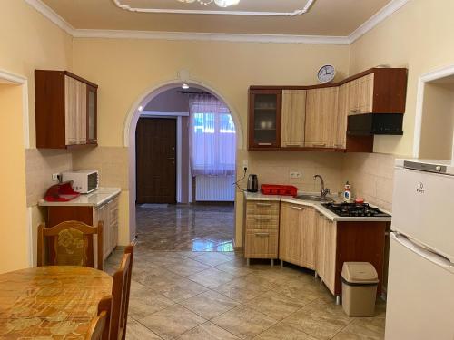 a kitchen with wooden cabinets and a table in it at Будинок для відпочинку Патріція in Berehove