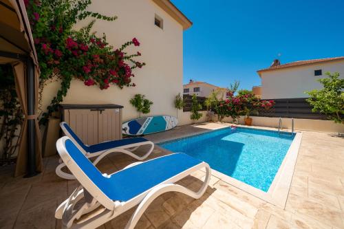 a patio with a pool and a chair next to a building at Anna-Maria 3 bedroom villa in Paralimni