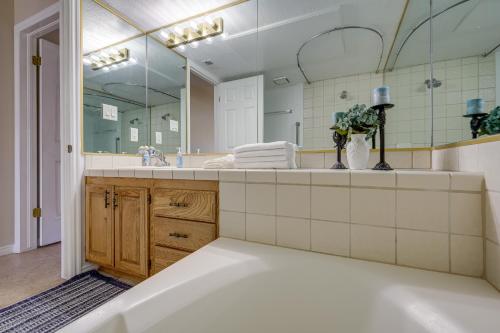 a bathroom with a tub and a large mirror at St George Resort Condo Near Zion National Park! in St. George
