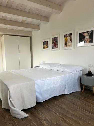 a bedroom with a large bed with white sheets at L’angolo degli aromi in Ragusa