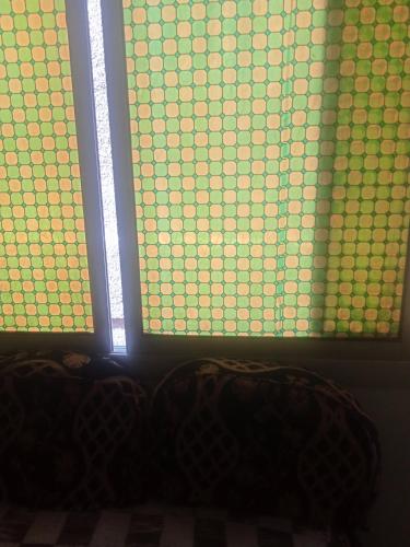 una ventana con cuadrados verdes y amarillos. en الخصوص القليوبيةمصر en El Cairo