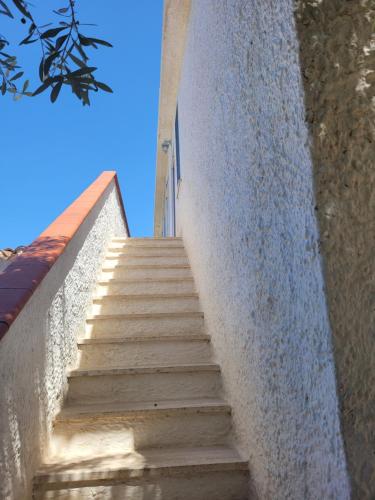 a staircase leading up to a building with a blue sky at Villa Maddalena guest house in Sorso