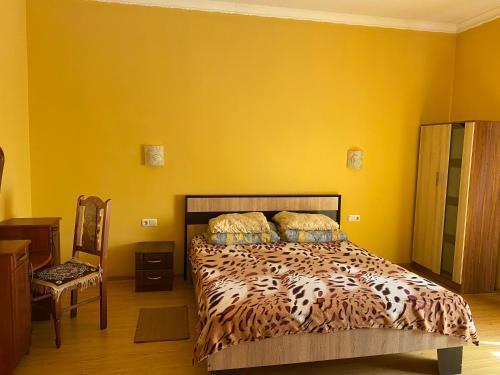um quarto com uma cama e uma parede amarela em Будинок для відпочинку Патріція em Berehove