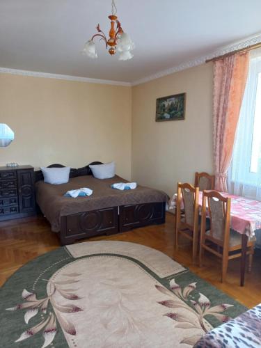1 Schlafzimmer mit 2 Betten, einem Tisch und Stühlen in der Unterkunft Hercules in Truskawez