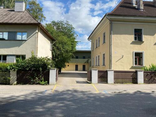 a parking lot in front of a building with a fence at Cozy flat at Tartu Old Town in Tartu