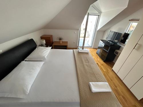 1 cama blanca grande en una habitación con TV en Apartments Sanda 2, en Promajna