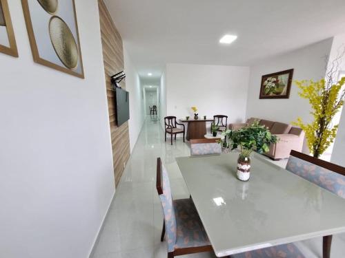 a dining room and living room with a table and chairs at Sobrado a 200m da Praia e Orla, 02 QTS com ar condicionado in Aracaju