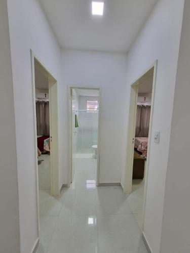 an empty hallway with white walls and white floors at Sobrado a 200m da Praia e Orla, 02 QTS com ar condicionado in Aracaju