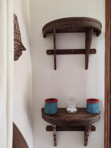 a wooden shelf on a wall with two bowls on it at Kisuri Resort in Sena