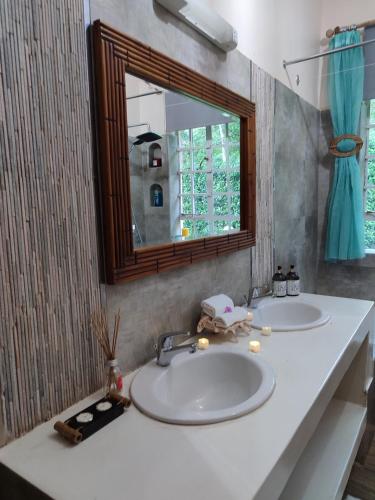 a bathroom with two sinks and a mirror at Kisuri Resort in Sena