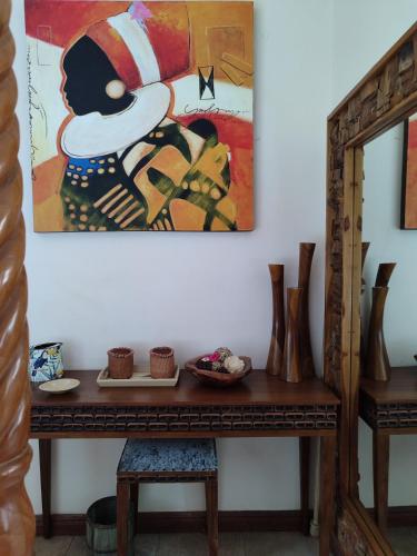 a table with a painting on the wall and a mirror at Kisuri Resort in Sena