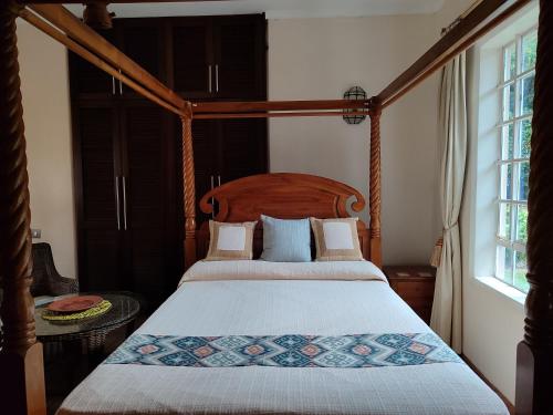 a bedroom with a four poster bed and a window at Kisuri Resort in Sena