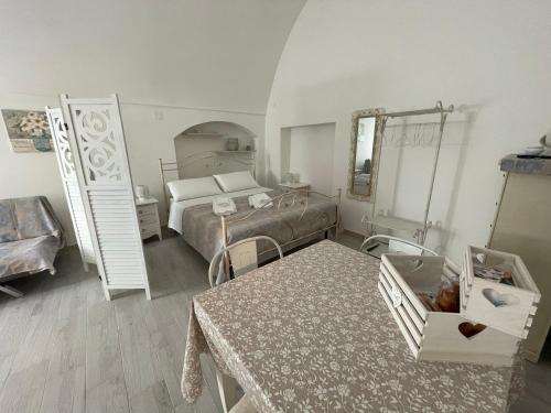 een slaapkamer met een bed en een tafel met een tafel sidx sidx sidx bij Unda Maris in Cisternino
