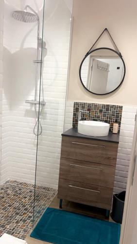 une salle de bain avec un lavabo et un miroir dans l'établissement Bel appartement dans Villa avec piscine en Corse du Sud, à Grossa