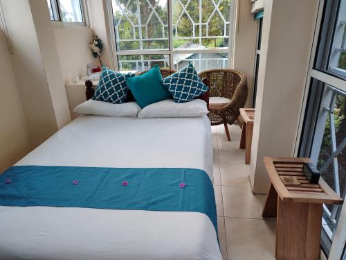a bedroom with a large bed with blue and white pillows at Kisuri Resort in Sena