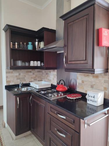 a kitchen with wooden cabinets and a stove top oven at Kisuri Resort in Sena