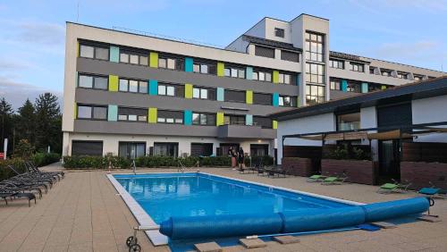a large building with a swimming pool in front of a building at Levander Apartman in Balatonföldvár