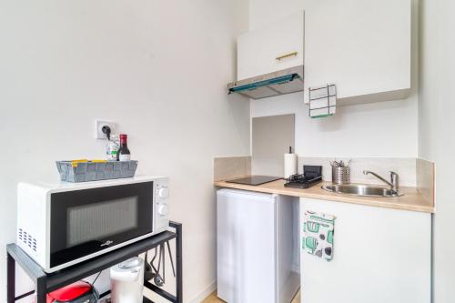 a kitchen with a sink and a tv and a refrigerator at 1225Location in Cambrai