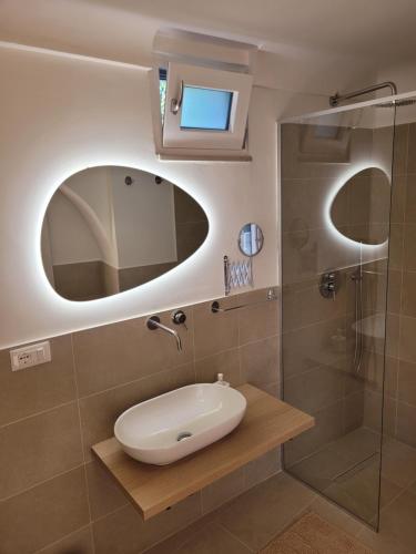 een badkamer met een wastafel en een douche bij Trullo il Gelso in San Michele Salentino