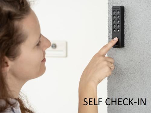 a woman is pressing a button on a wall at La Casa de Papel - Berlino - Self Check in, Smart Tv, tutti i confort, nuova costruzione in Cavarzere