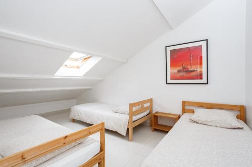 a attic bedroom with two beds and a window at Le blanc droit 3éme étage droite 23A in Le Blanc-Mesnil