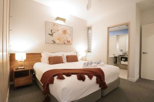 a bedroom with a large white bed and a bathroom at Tranquil treetop retreat minutes from the beach 7405 in Noosa Heads